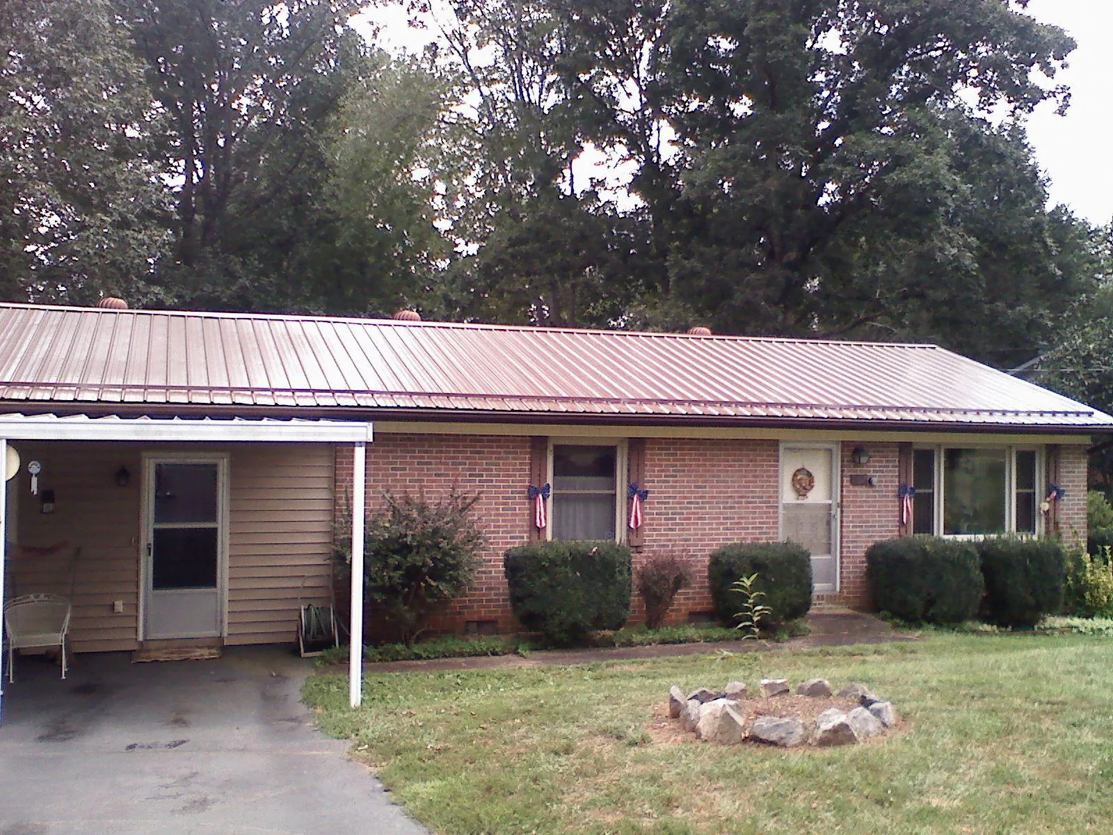 Bronze metal roof and carport on a brick ranch home — Roof Repair work by our crew in Blountville